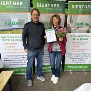 Der Geschäftsführer der Bierther GmbH übergibt einer Mitarbeiterin zum 10jährigen Jubiläum eine Urkunde.